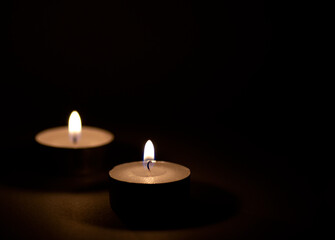 Obraz na płótnie Canvas Burning candles flame on dark surface.