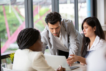 cheerful young business people giving high-five while their colleagues looking at them and smiling