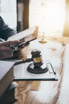 Focus At Wooden Gavel With Lawyer Reading Book Of Law, Vertical Image.