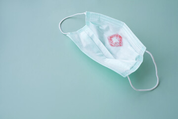 Protective medical face mask with red lipstick kiss print on a green background