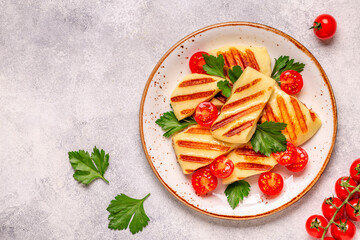 Grilled halloumi cheese served with tomatoes and parsley