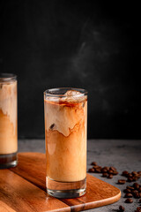 Ice coffee in a glass with cream poured over.