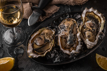 Fresh oysters close-up on ice served with lemon and wine.
