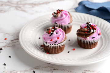 closeup of strawberry chocolate valentines day cupcakes on a white plate