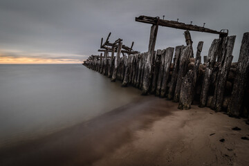 A beautiful shot of a seascape and some benches near during the sunset - Powered by Adobe