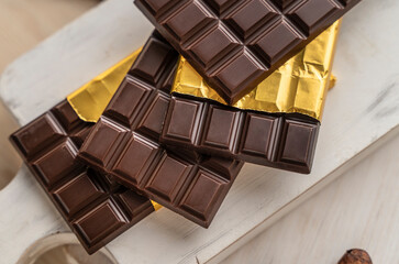 Chocolate bars with open gold cover. Stack of chocolate bars. Flat lay composition with delicious chocolate isolated on white background. Space for text