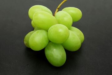fresh green grapes bunch closeup in black background