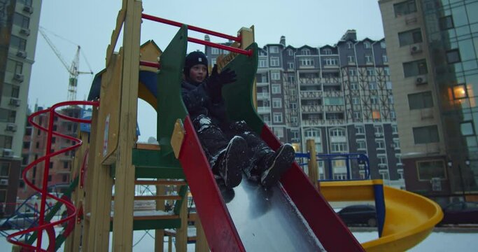 The concept is not to give up. A 10-year-old optimistic boy rolls down a winter slide unsuccessfully - falls, but rises like a champion.