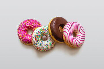 Bright multicolored donuts with icing, on a light background