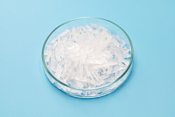 menthol crystals in a petri dish isolated on sky blue background