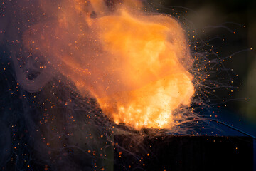Fototapeta na wymiar Flame explosion of Cracker gunpowder in a spoon with a lot of smoke bubbling and pushing upward