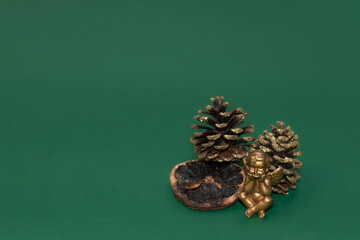 Weihnachtsdekoration. Kleine goldene Engelsfigur mit goldener Dekoration aus Tannenzapfen auf einem...