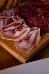 Cheese and meat board in an Italian restaurant in Cremona, Lombardy, Italy with mozzarella, prosciutto, salami, ham, brie, parmesan, bread sticks. Italian food in Europe. European antipasti and snacks