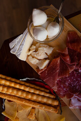 Cheese and meat board in an Italian restaurant in Cremona, Lombardy, Italy with mozzarella, prosciutto, salami, ham, brie, parmesan, bread sticks. Italian food in Europe. European antipasti and snacks