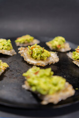 Pork rinds with guacamole on traditional Mexican comal