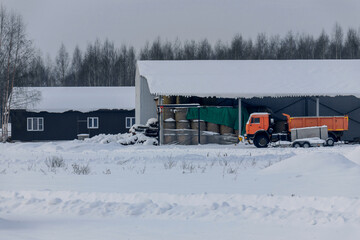 Construction site and heavy truck parking for farm maintenance. Winter landscape