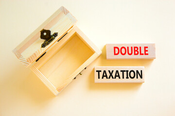 Double taxation symbol. Concept words Double taxation on wooden blocks on a beautiful white table white background. Empthy wooden chest. Business tax and double taxation concept, copy space.