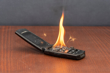Old mobile phone burns with fire, battery fire.  The cause of the fire in the apartment, short...