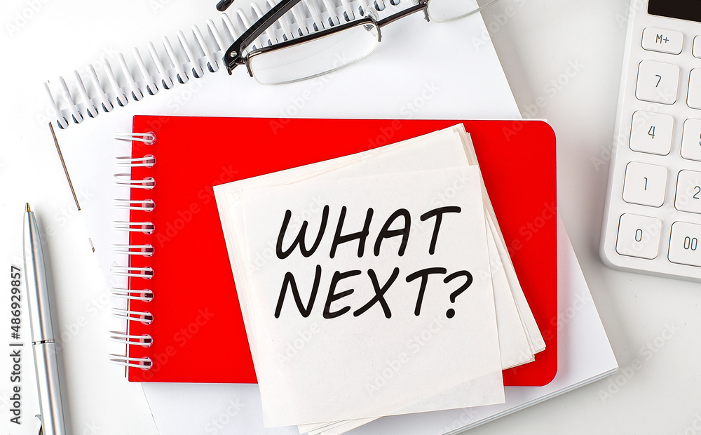 Poster what next word on sticker on notepad with pen and calculator