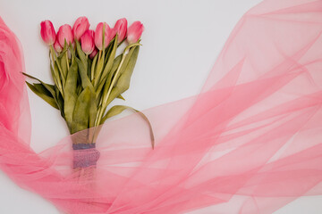 Fototapeta na wymiar bouquet of pink tulips. Tulips on a pink tulle. Copys pace. Pink bouquet