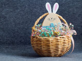 Fototapeta na wymiar Easter bunny flowers basket decoration on grey background.