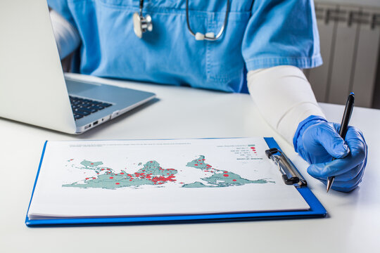 Medical worker analyzing COVID-19 world map - Powered by Adobe