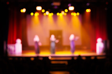 Fototapeta na wymiar Blur and defocus scene. Stage light at a concert show. Artists perform on scene in light and smoke.
