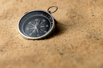 Fototapeta na wymiar Compass on the sand at the beach. Concept of travel or direction
