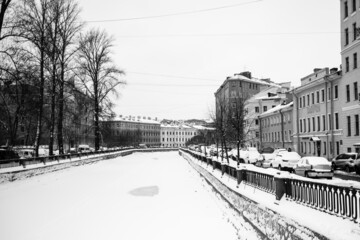 View of the Griboyedov Canal under the ice in winter, St. Petersburg, Russia. Black and white photo.