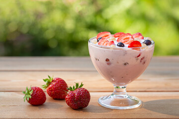 Yogurt with summer berries on a wooden table. Healthy food rich in fiber, vitamins and antioxidants.