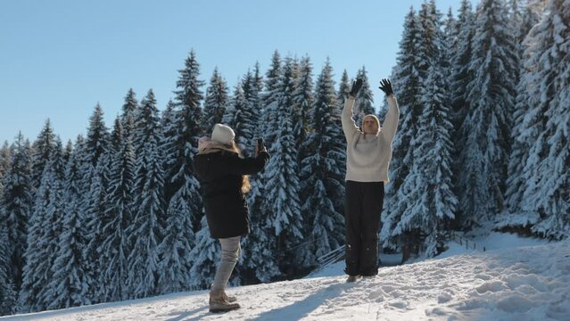 Friends Taking Photos with Smartphone on a Sunny Winter Day on a Ski Slope and Having Fun in the Snowy Forest, Laughing and Having a Good Time on Winter Season, Outdoor, Wide, Slow Motion