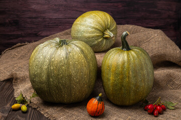 three green pumpkins on a wooden table