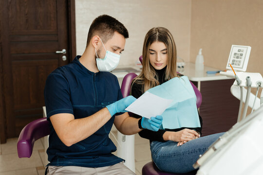 A young woman at the dentist's reception examines the picture