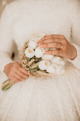 bridal flower in bride's hand, focused on one hand and tulip