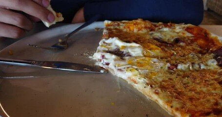 Young african man eating pizza in restaurant