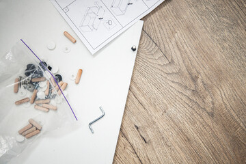 Furniture assembly, furniture assembly instructions on a wooden background. Top view, flat lay.