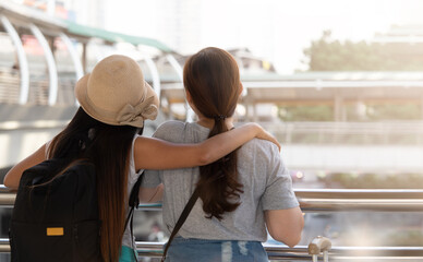 Rear view of two Asian female tourists looking at view of the city