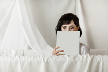 brunette businesswoman with books moke up, reads or keeps in a white shirt, studio isolated...