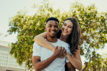 Obraz premium Portrait of biracial couple hugging in the park