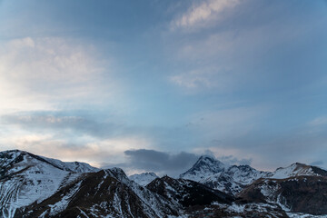 Panoramic view of the high snow covered mountain Kazbek at the sunrise.  Winter mountains landscape. Georgia,  Kazbegi.