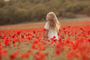 Pretty little girl on a poppy field, outdoor