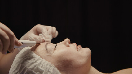 Woman cleansing facial in spa salon. Water oxygen face h2o2 small bubble facial rf lifting equipment skin care microdermabrasion machine. Wellness face care beauty treatment, rejuvenation procedure