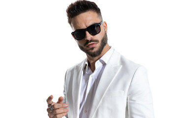 portrait of unshaved businessman with sunglasses posing in a studio light
