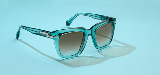 Sunglasses on pastel blue background in sunlight. Modern stylish sunglasses for beautiful holiday vacation. Fashion female summer eyeglasses