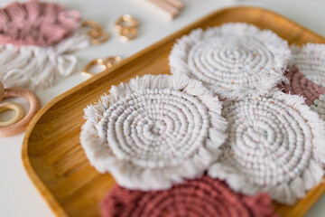 Macrame eco decorations, ornaments, hand made decor. Natural materials, cotton thread. White macrame coaster on wooden table, Food decoration