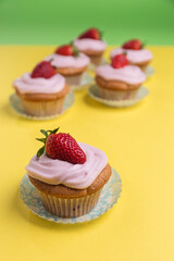 Natural strawberry cupcake and cream on yellow background