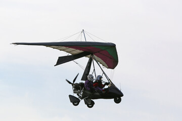 Ultralight airplane flying in a blue sky	