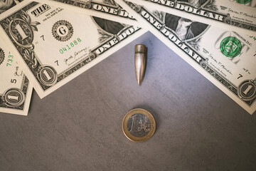 dollar bills bullet pointing towards euro euro coin on gray table