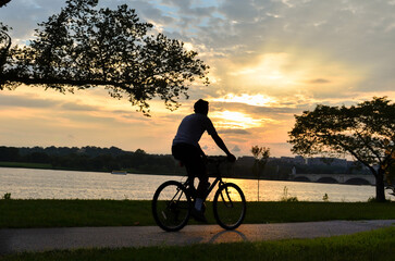 Silhouette of a woman riding a bicycle at Rock Creek Trail in Washington, DC, United States