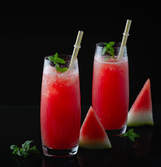 Refreshing summer watermelon juice in glasses with slices of watermelon